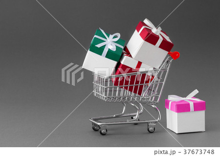 Mini shopping cart full of colorful gift boxes. Mini shopping cart full of colorful gift boxes. 37673748