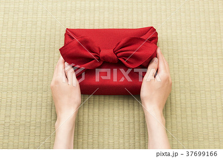 風呂敷包の手土産を渡す女性の手 37699166