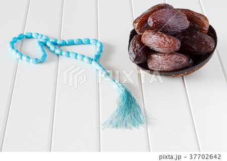 Fresh dates Medjool in coconut bowl and rosary. 37702642