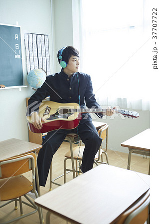 教室でギターを弾く男子生徒の写真素材