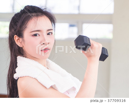 Chinese woman looking strong lifting up dumbbell 37709316