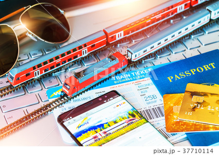 Toy train, tickets, passport and bank card on laptop or notebook 37710114