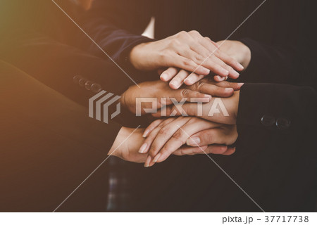 Business people making pile of hands Business people making pile of hands 37717738
