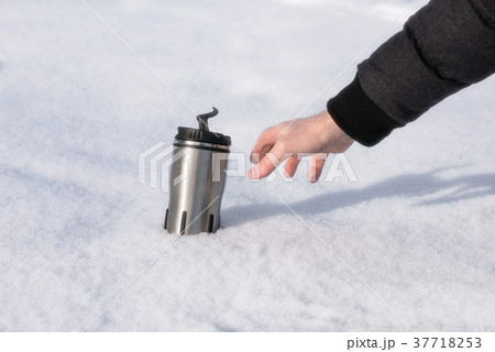 A man's hand reaches for a thermos with hot coffee 37718253