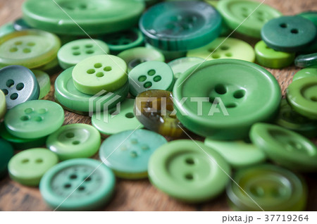green sewing buttons on wooden background 37719264