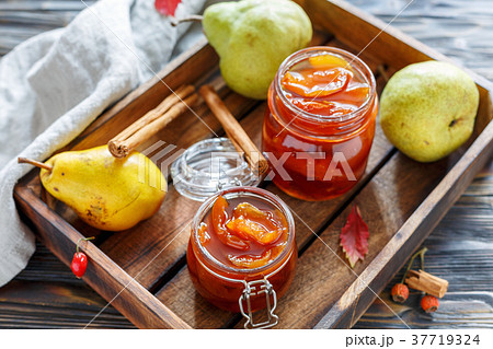 Jam from pears in glass jars and fresh pear. 37719324