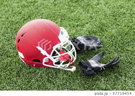 Red football helmet with balck gloves on the field Red football helmet with balck gloves on the field 37719454