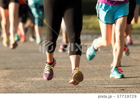 Runners legs at a 5K on a dirt psth 37719729