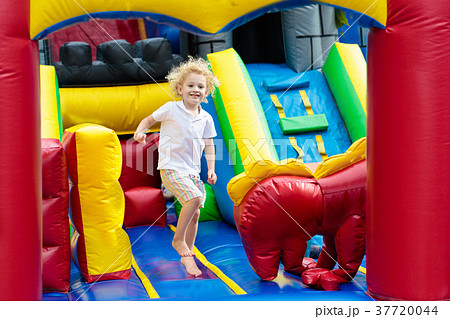Child jumping on playground trampoline. Kids jump. 37720044