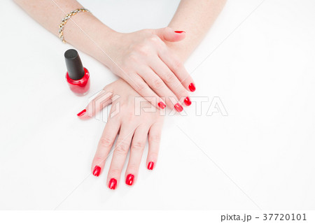 Female hands with manicure and red lacquer on a Female hands with manicure and red lacquer on a 37720101