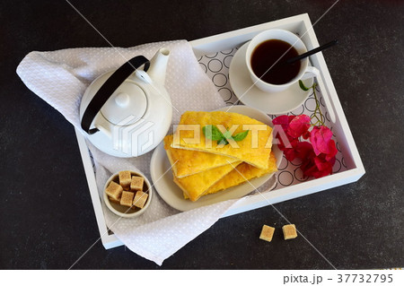 Cheesy pancakes with tea on a wooden tray. 37732795