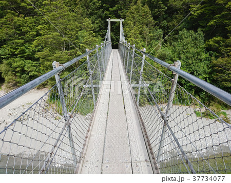 Walking suspension bridge into tropical jungle 37734077