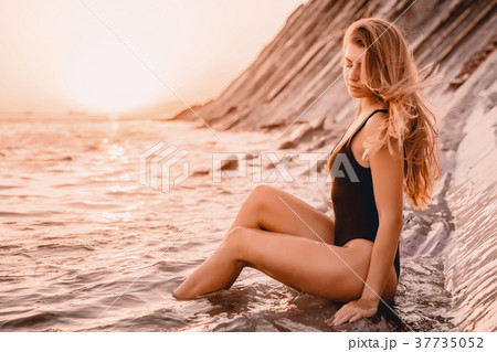 Attractive fit woman in black bikini on ocean Attractive fit woman in black bikini on ocean 37735052