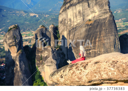 Alone girl on a top of the rock of Meteora,Greece Alone girl on a top of the rock of Meteora,Greece 37736383