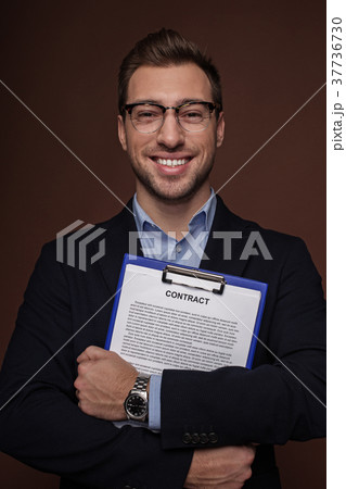 Cheerful businessman holding documents in arms 37736730