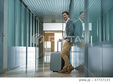 Pleasant man is waiting for flight with luggage Pleasant man is waiting for flight with luggage 37737135