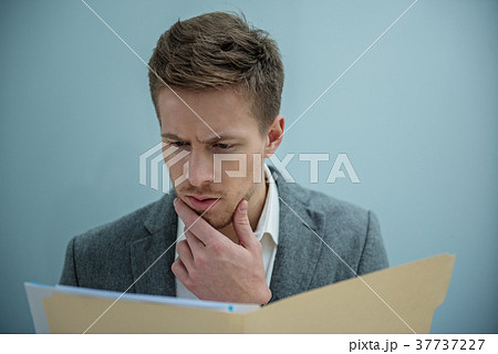 Pensive professional employee is holding documents 37737227
