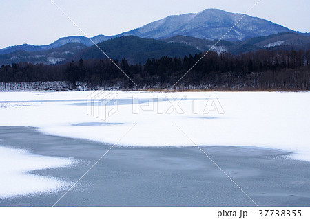 全面凍結の御所湖と周囲の山並みの雪景色 37738355