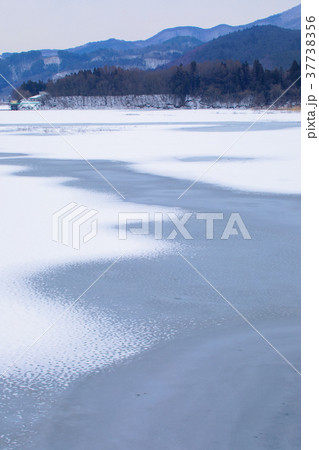 全面凍結の御所湖と周囲の山並みの雪景色 37738356