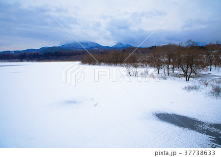 全面凍結の御所湖と周囲の山並みの雪景色 37738633