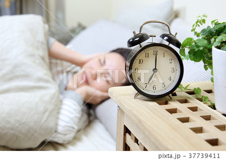 目覚まし時計と若い女性 37739411