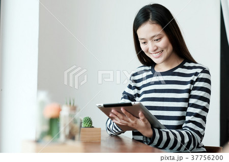Young asian woman using tablet in cafe background 37756200