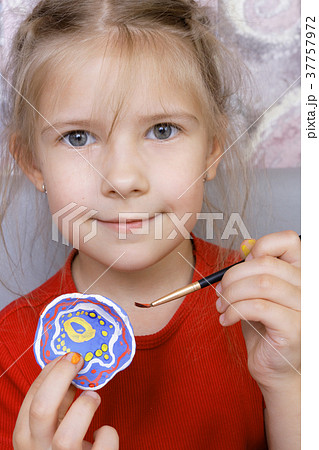 Girl with painted homemade clay cup 37757972