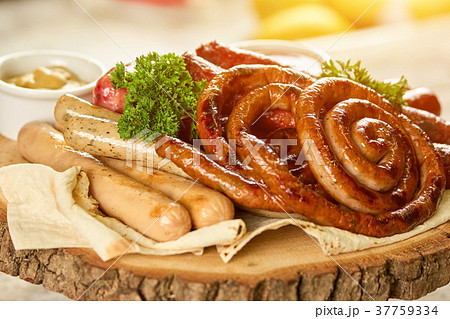 Sausage assortment dish on round wooden plate. 37759334