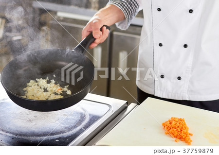 Chef frying chopped white onion. 37759879