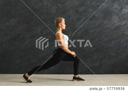 Fitness woman stretching at grey background 37759936