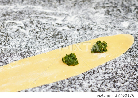 Two little piles of greens on dough sheet. 37760176