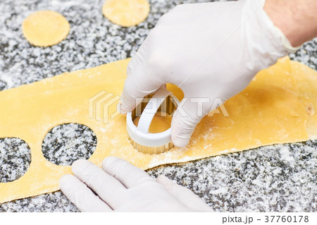 Making round holes on dough using metal form. Making round holes on dough using metal form. 37760178