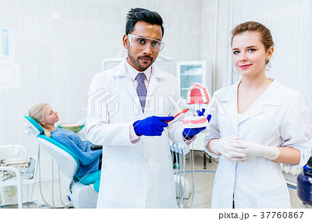 Two Dentist showing jaw model in clinic 37760867