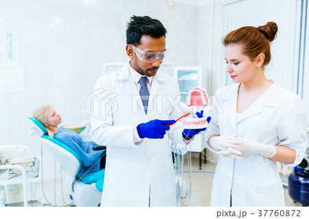 Two Dentist showing jaw model in clinic Two Dentist showing jaw model in clinic 37760872