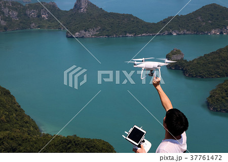 Hands holding a remote control and drone camera  37761472