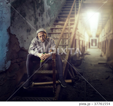 Bad guy with bottle of alcohol sits on stairs Bad guy with bottle of alcohol sits on stairs 37761554