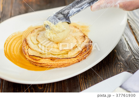 Adding ice cream ball to an apple tart. Adding ice cream ball to an apple tart. 37761930