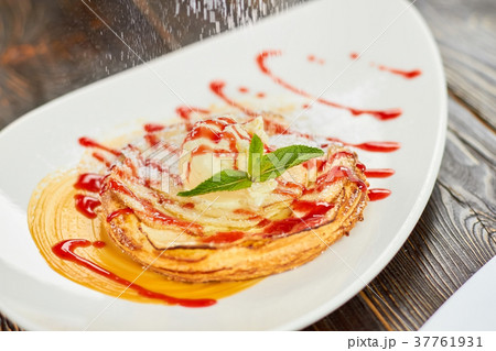 Apple tart with jam flouring with white powder. 37761931