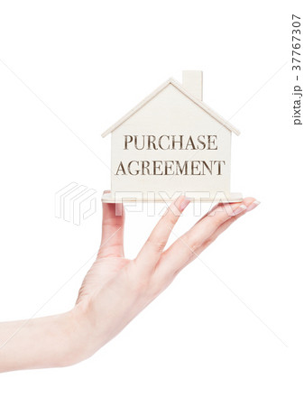 Female hand holding wooden house model with text 37767307