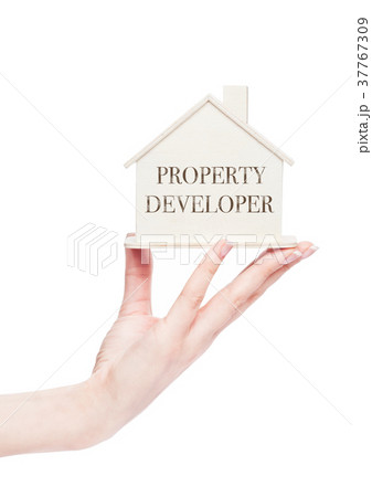 Female hand holding wooden house model with text 37767309