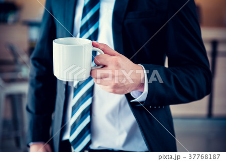 Businessman with coffee, smart standing in office 37768187