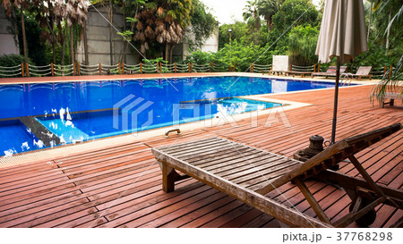 Wooden sunbed with umbrella on  swimming pool 37768298