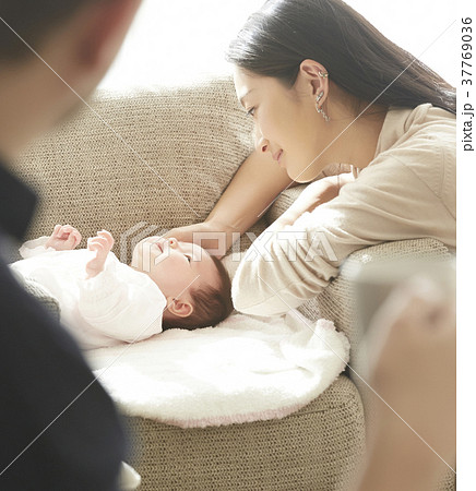 赤ちゃんを慈しむ両親 37769036