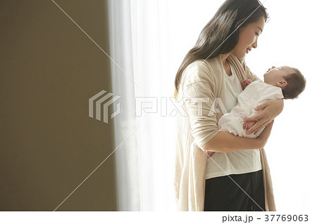 赤ちゃんを抱く女性の写真素材