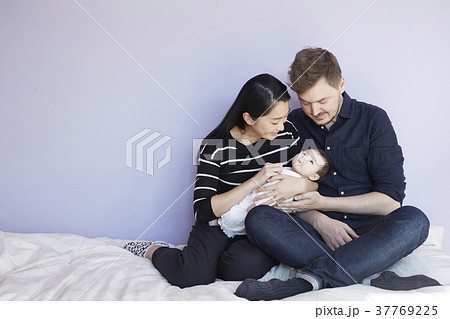 子供部屋で赤ちゃんを慈しむ両親 37769225