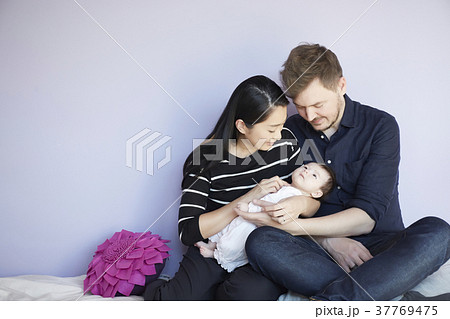 子供部屋で赤ちゃんを慈しむ両親 37769475