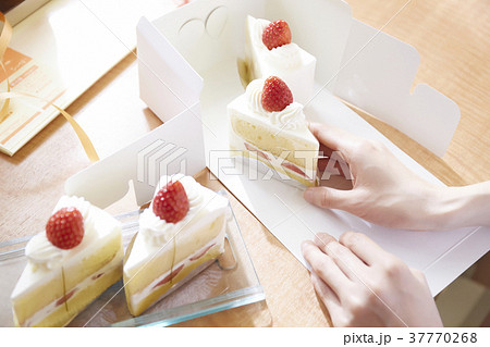 ケーキ屋さんで箱詰めする手の写真素材