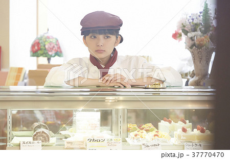 ケーキ屋でアルバイトをする女性の写真素材