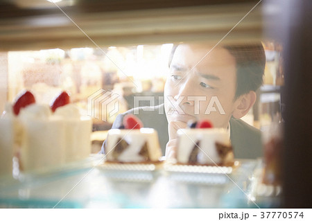 ケーキを買いに来たビジネスマンの写真素材