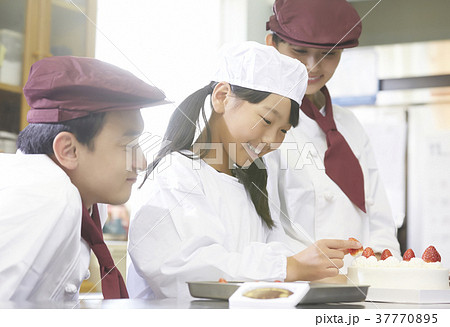 ケーキ屋の仕事を手伝う子供の写真素材